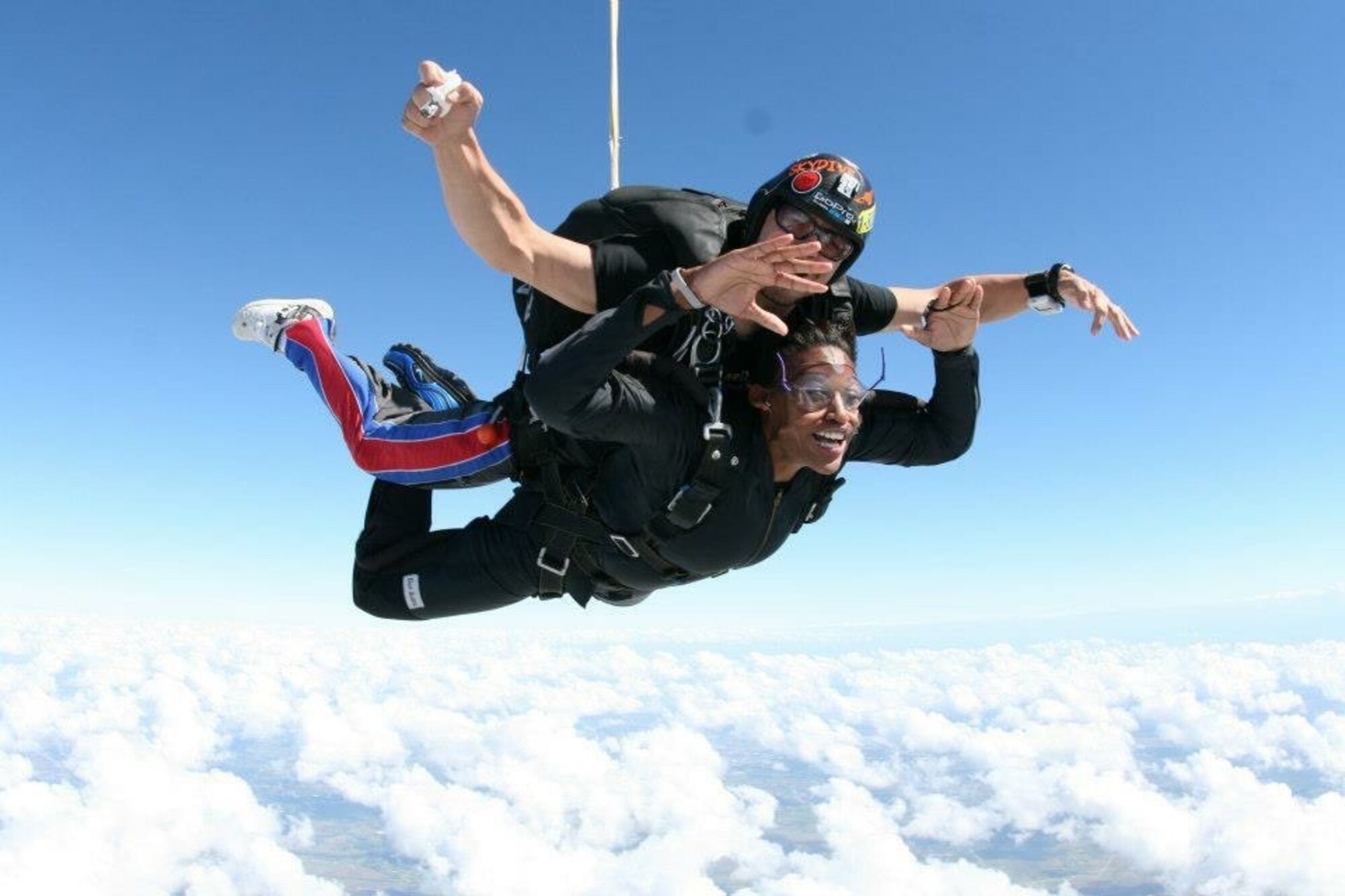 Khaliah O. Guillory in tandem free-fall skydiving above the clouds