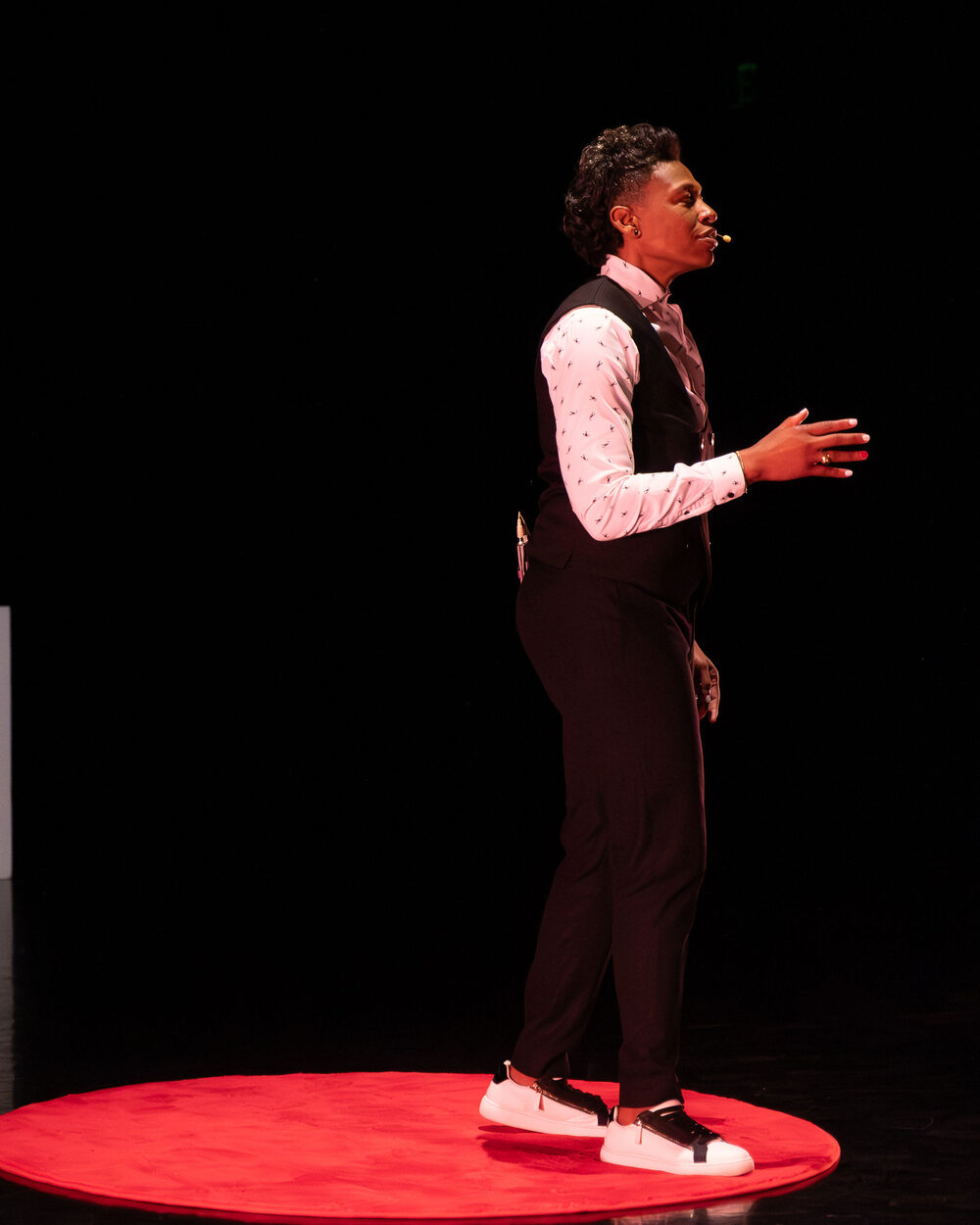 Khaliah O. Guillory mid-talk on the red TEDx stage circle
