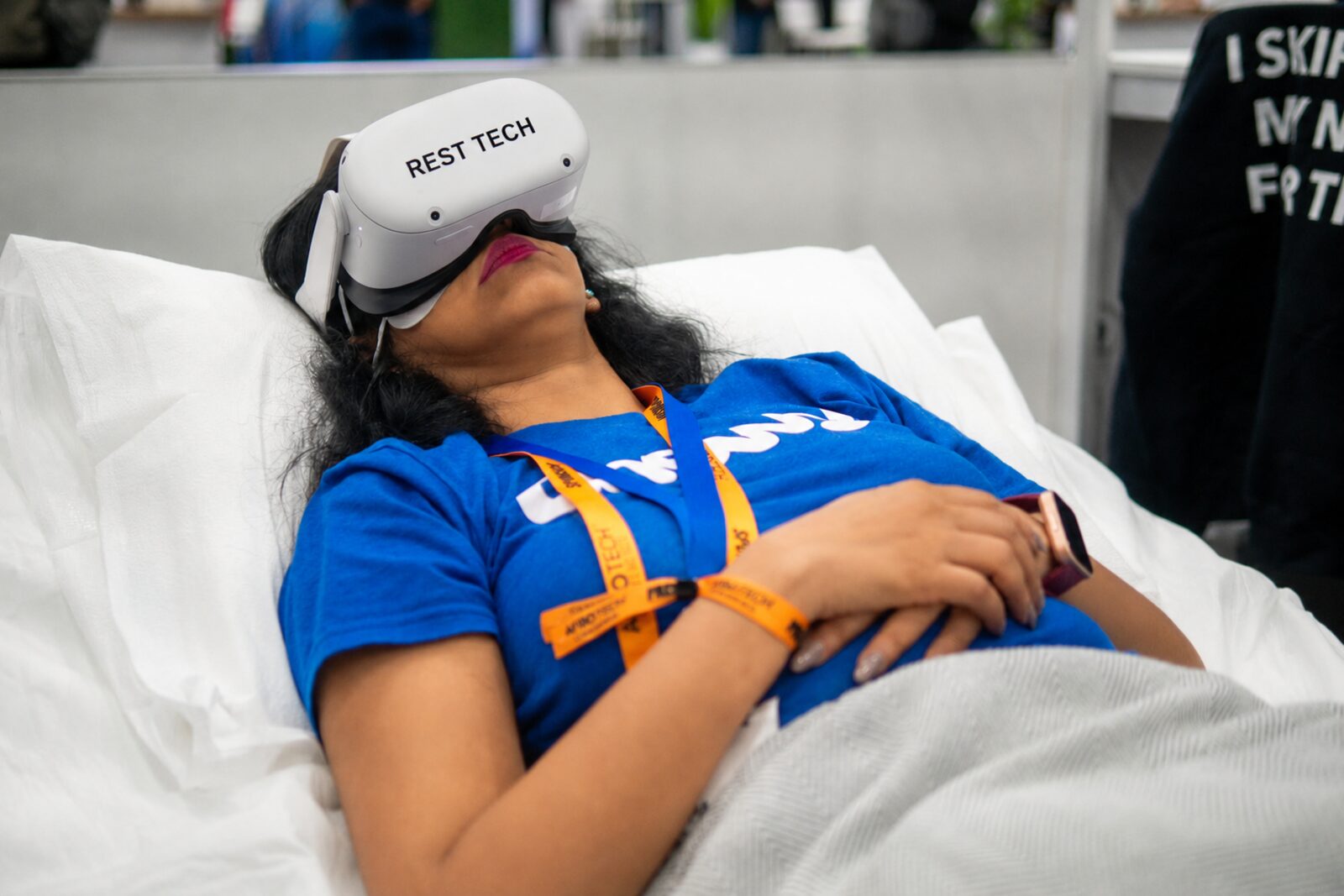 A Rest Tech recovery station set up on a conference floor with a participant mid-session in a VR headset.